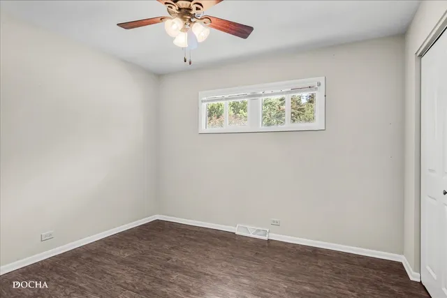 an empty room with a window and wooden floor