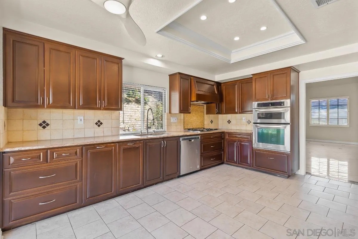 404 Summerhill Terrace Alpine, CA 91901 - Photo 7 of 40 a large kitchen with kitchen island granite countertop a large counter top stainless steel appliances and cabinets