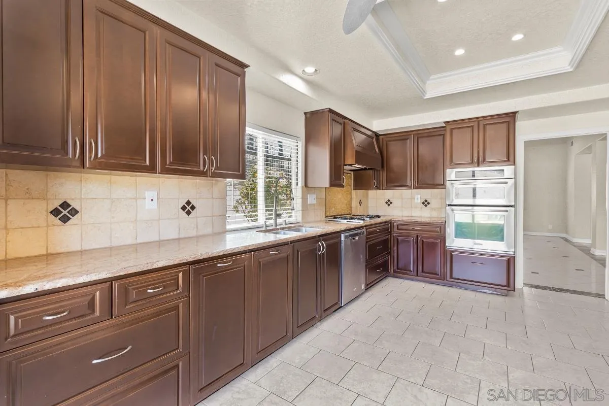404 Summerhill Terrace Alpine, CA 91901 - Photo 10 of 40 a large kitchen with stainless steel appliances wooden cabinets a sink and a stove