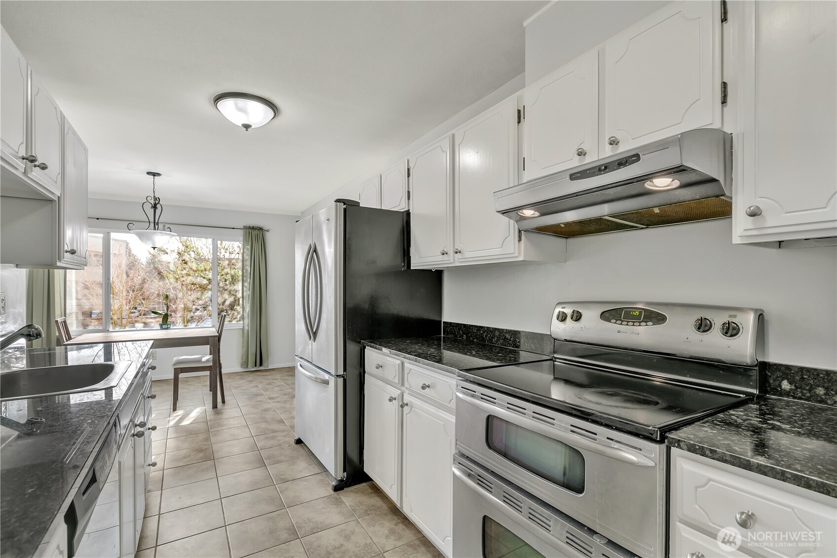 4545 Sand Point Way Northeast, Unit 207 Seattle, WA 98105 - Photo 9 of 25 a kitchen with stainless steel appliances granite countertop a sink a stove a refrigerator and cabinets