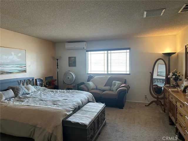 a bedroom with bed couch and window