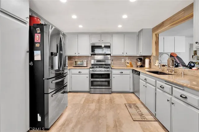 a kitchen with granite countertop a sink and steel appliances