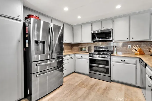 a kitchen with granite countertop a sink stainless steel appliances and cabinets