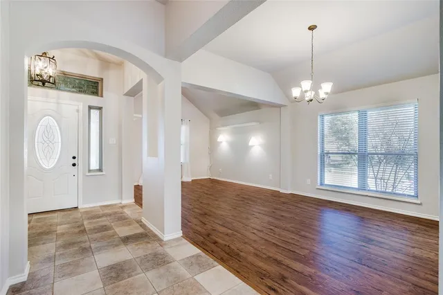 a view of an empty room with wooden floor and a large window