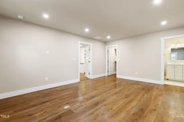 a view of an empty room with wooden floor and closet