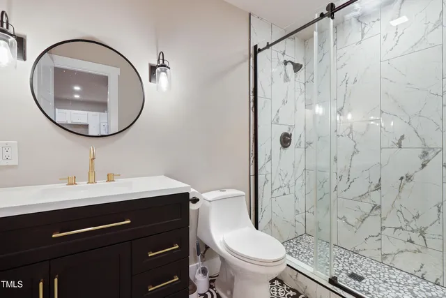 a bathroom with a sink a toilet and a mirror