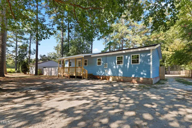 a view of a yard in front of a house with large trees