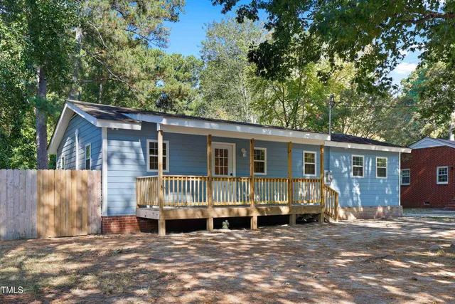 a view of a house with a large window and wooden fence