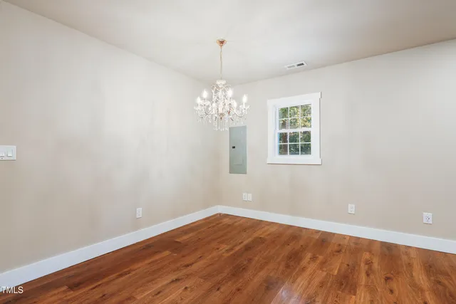 a view of a room with wooden floor and chandelier