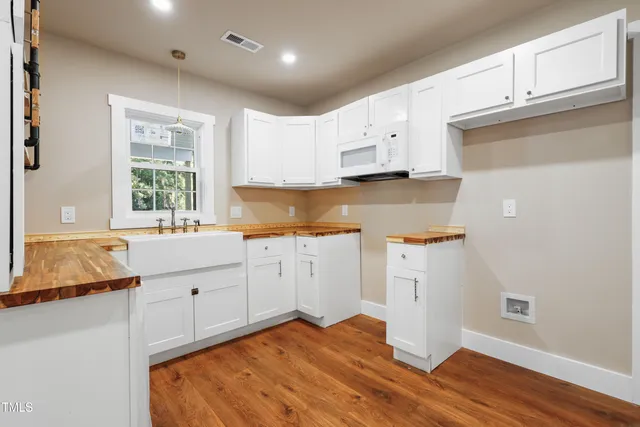 a kitchen with granite countertop white cabinets and white appliances