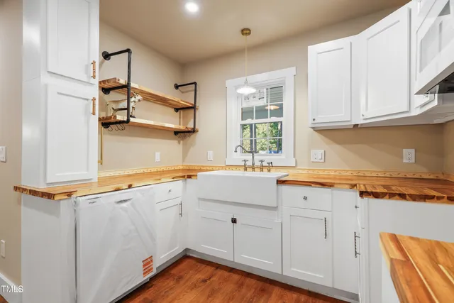 a kitchen with granite countertop white cabinets and a sink