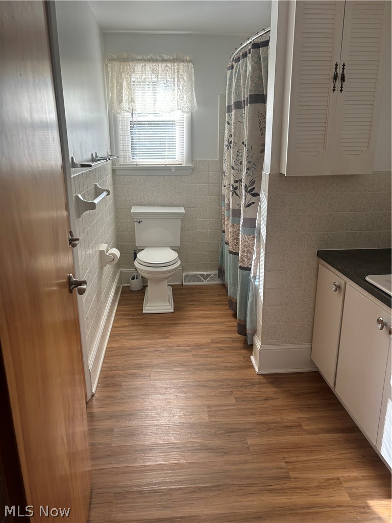 64197 Morrison Road Cambridge, OH 43725 - Photo 31 of 41 Bathroom featuring tile walls, wood-type flooring, and toilet