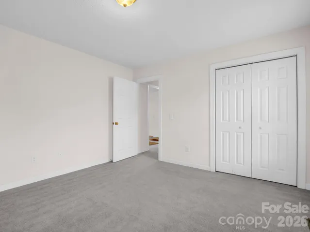 a front view of a house with a yard and large trees