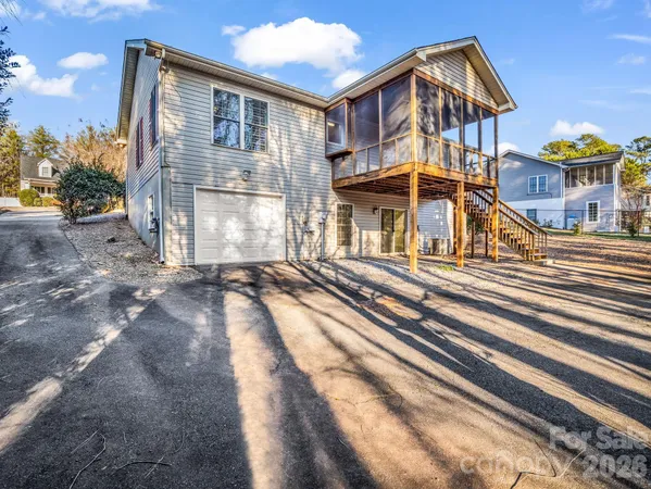 an empty room with chandelier fan and windows