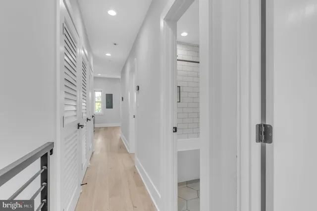a view of a hallway with wooden floor and staircase