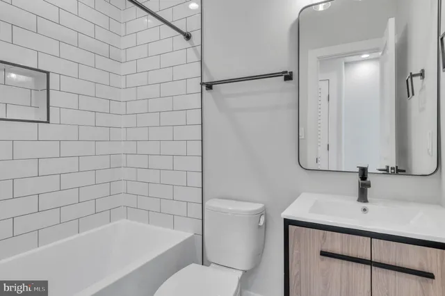 a bathroom with a bathtub shower sink vanity and toilet
