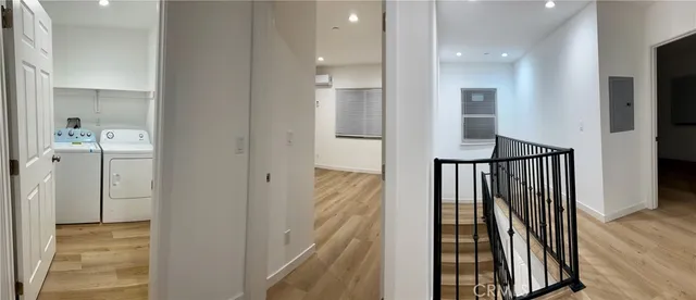 a view of a hallway with wooden floor and staircase