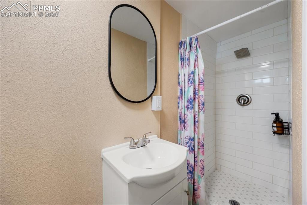 421 South Prospect Street Colorado Springs, CO 80903 - Photo 26 of 48 a bathroom with a sink a mirror a vanity and shower