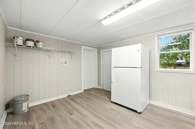 a view of a room with wooden floor and a window