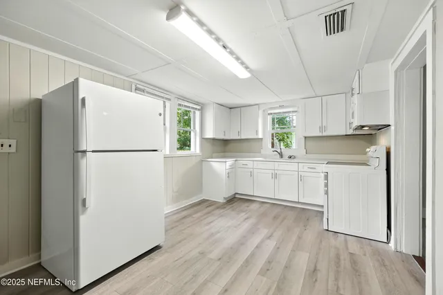 a kitchen with white cabinets and white appliances