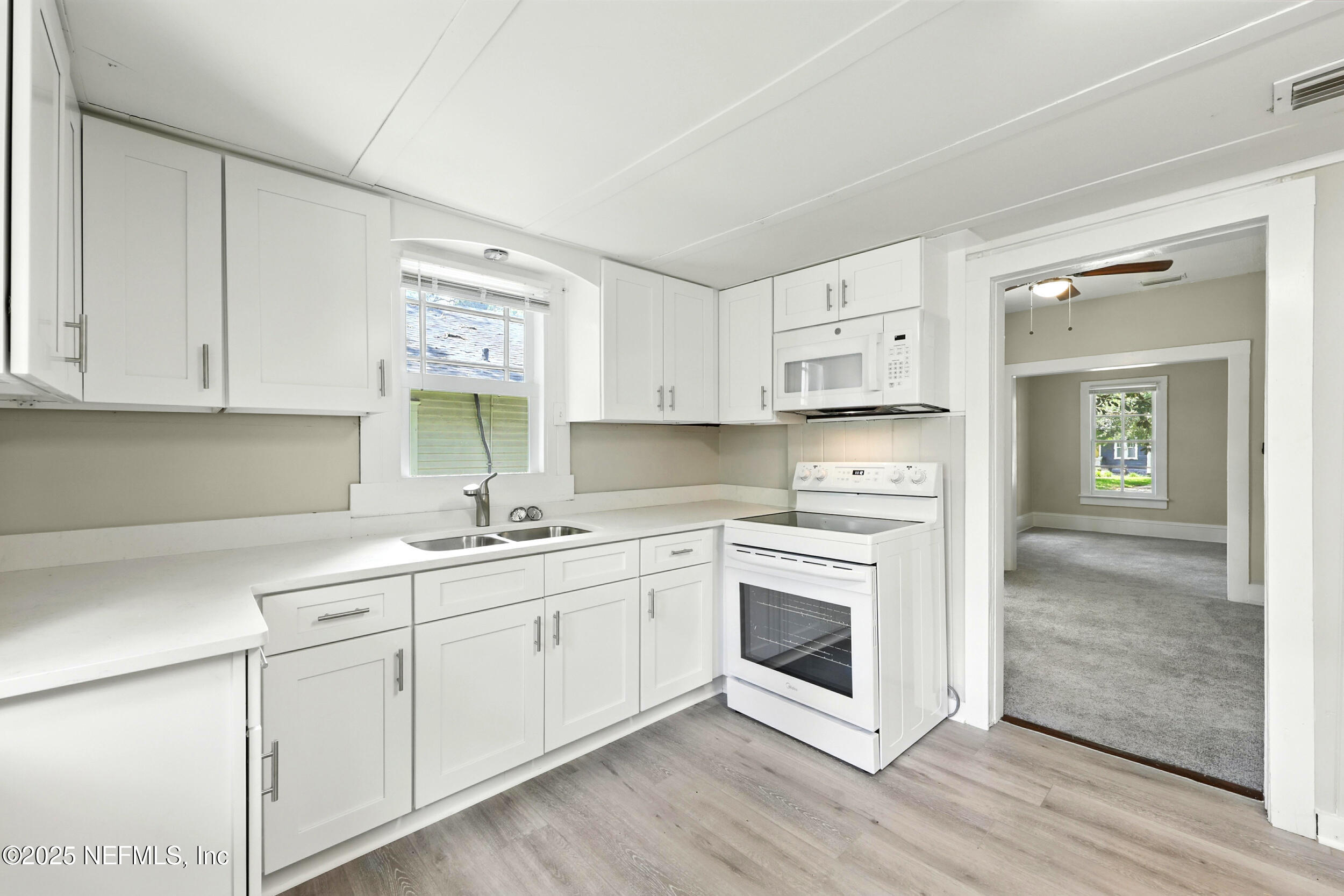 2858 Downing Street Jacksonville, FL 32205 - Photo 8 of 29 a kitchen with stainless steel appliances granite countertop a sink and cabinets with wooden floor