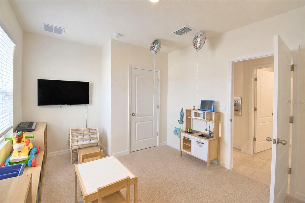 2839 Moulin Road Davenport, FL 33837 - Photo 24 of 75 a living room with furniture and a flat screen tv