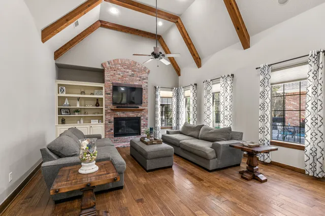 a living room with fireplace furniture and a large window