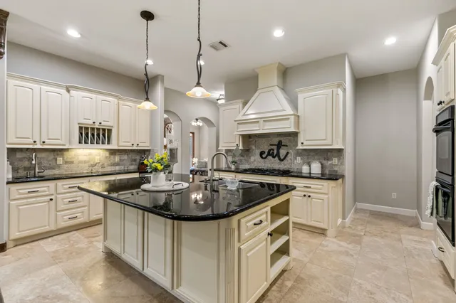 a kitchen with stainless steel appliances granite countertop a sink a stove and a refrigerator