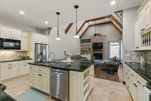 a kitchen with stainless steel appliances granite countertop a sink a stove and cabinets