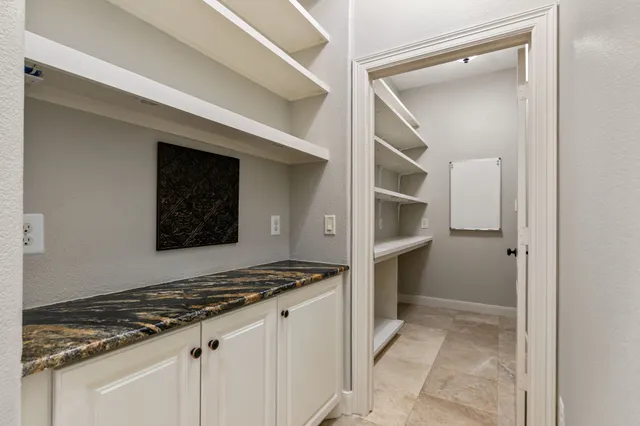 a kitchen with white cabinets and appliances
