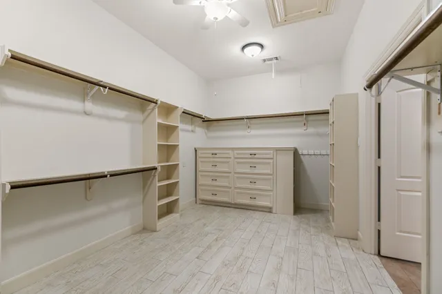 a view of walk in closet with empty racks