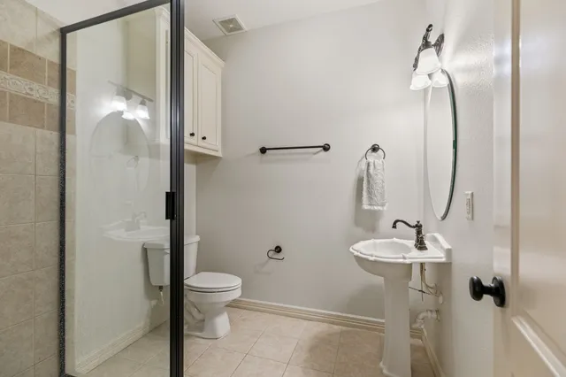 a bathroom with a granite countertop sink a toilet and shower