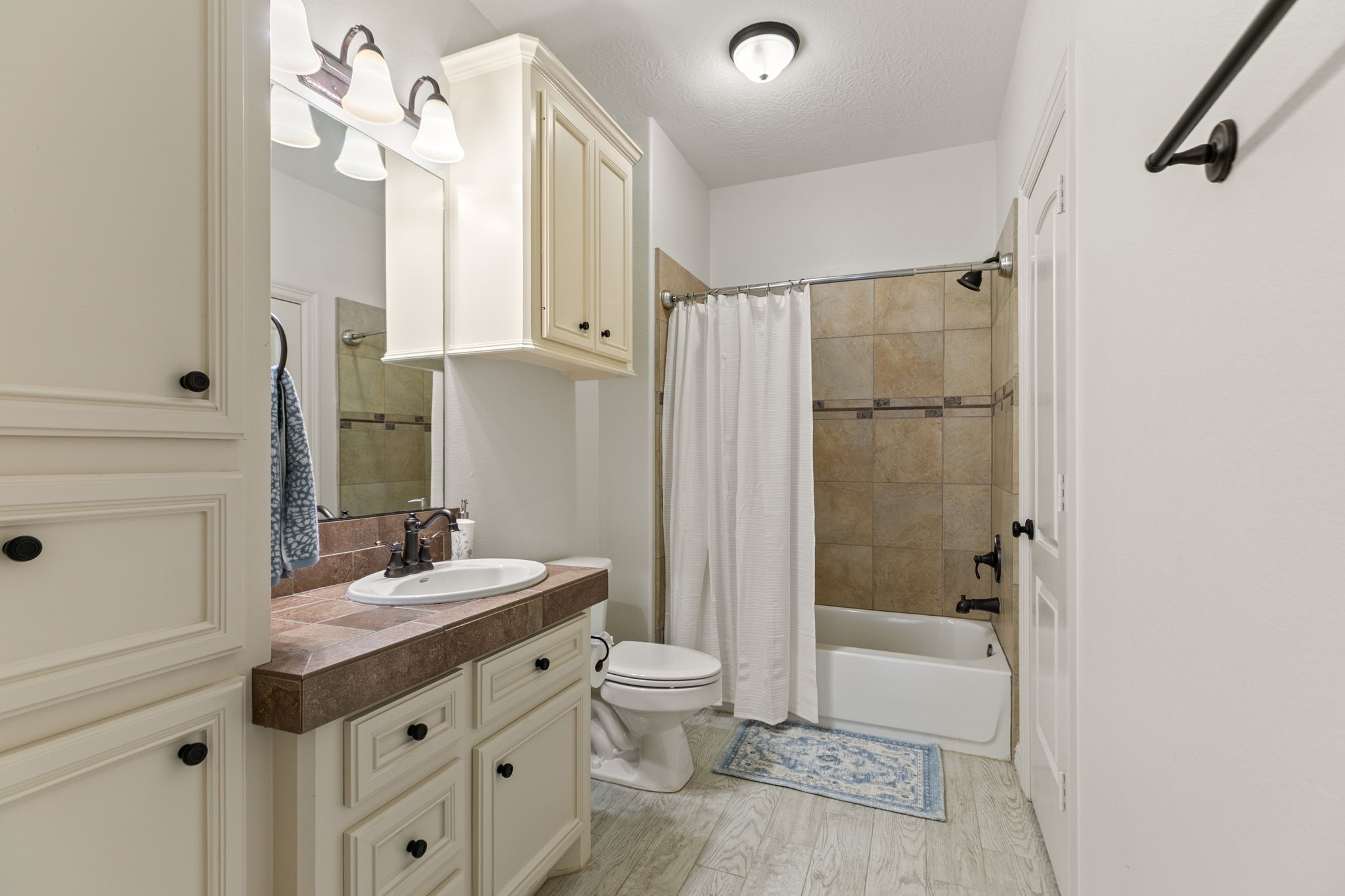 3811 Rayford Road Spring, TX 77386 - Photo 36 of 50 a bathroom with a sink a toilet a mirror and shower