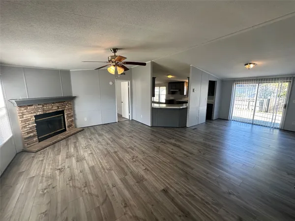 a view of empty room with wooden floor and fireplace