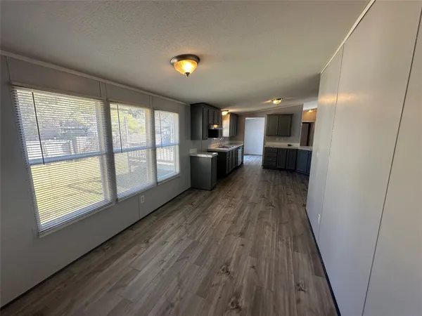 a view of a kitchen with a sink wooden floor and a window