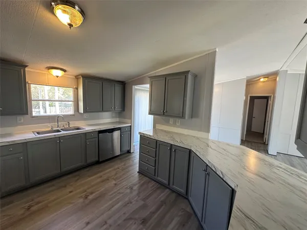 a large kitchen with stainless steel appliances wooden cabinets a sink and a dishwasher