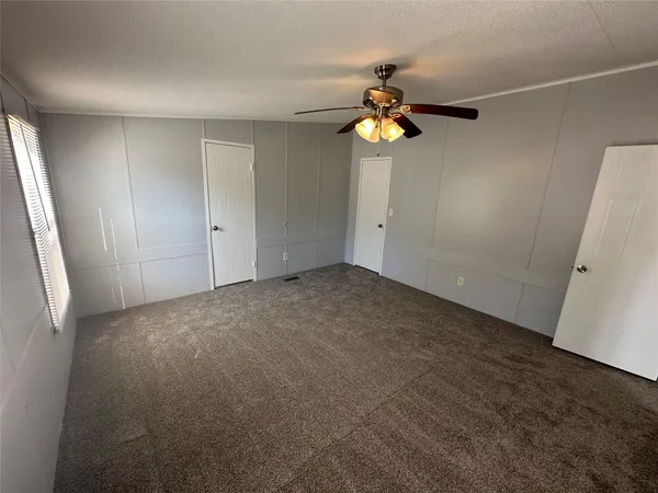 an empty room with a mirror and a fan