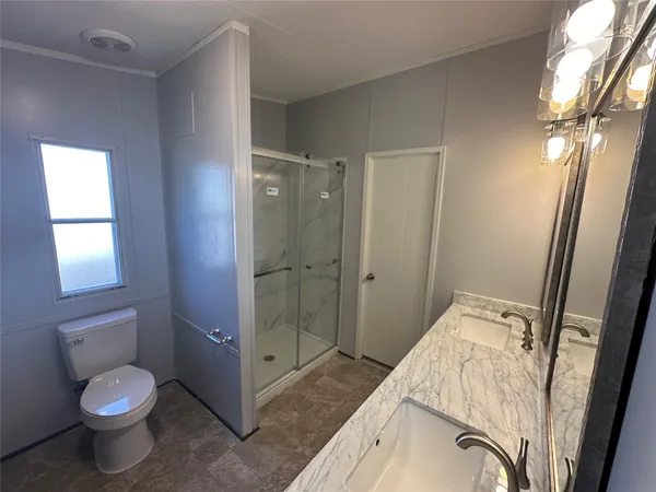 a bathroom with a granite countertop sink toilet and shower