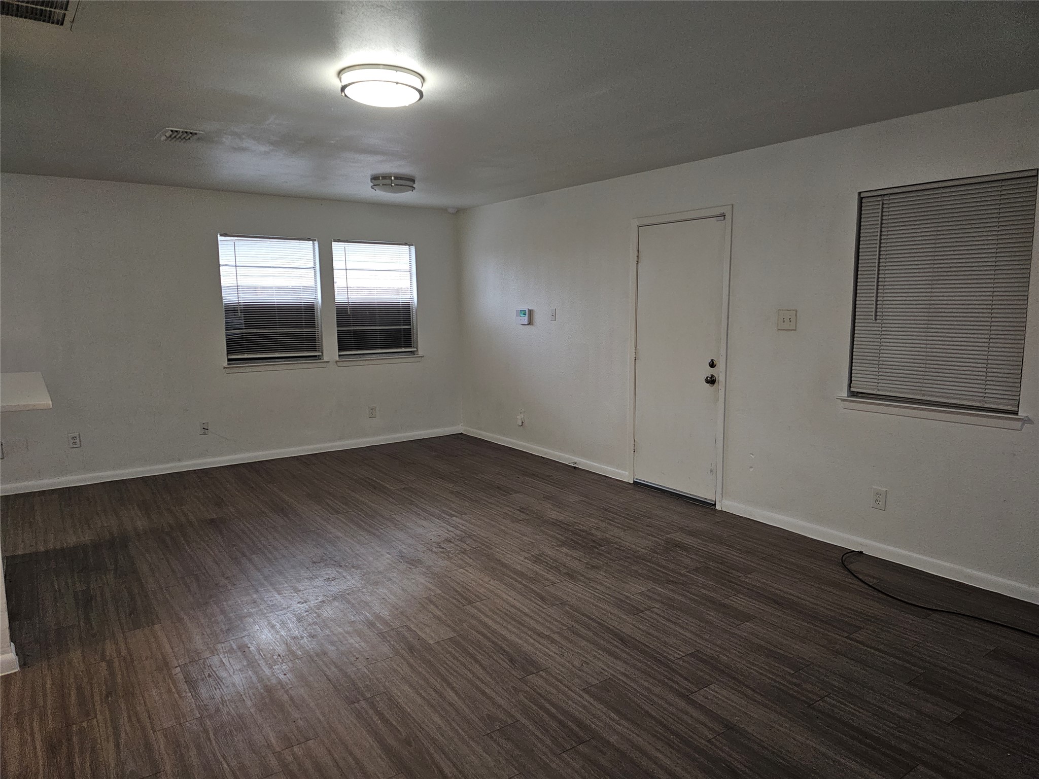 7300 Bennett Avenue, Unit B Austin, TX 78752 - Photo 2 of 11 an empty room with wooden floor and windows