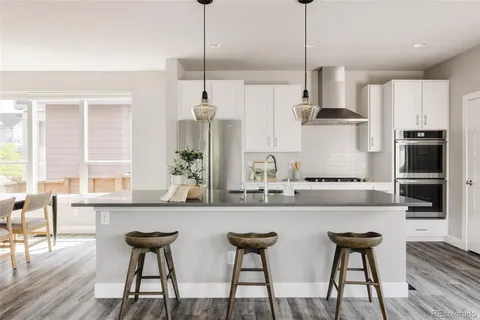 a kitchen with stainless steel appliances a kitchen island a stove a table and chairs in it