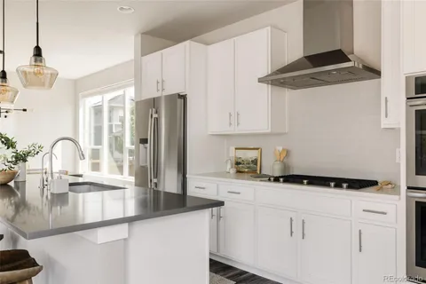 a kitchen with granite countertop a sink cabinets and stainless steel appliances