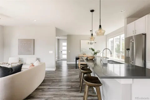 a living room with furniture a wooden floor and a chandelier