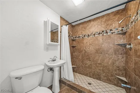 a bathroom with a shower a toilet and a sink