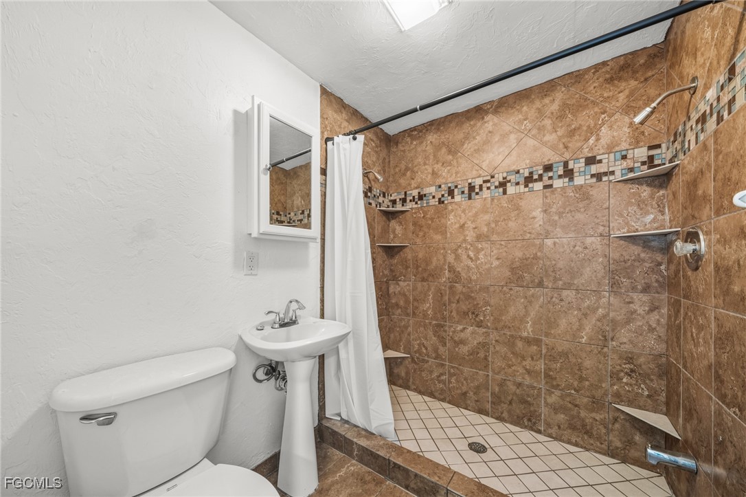290 Granada Boulevard Fort Myers, FL 33905 - Photo 15 of 37 a bathroom with a shower a toilet and a sink