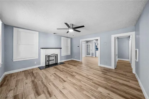 a view of empty room with wooden floor and ceiling fan