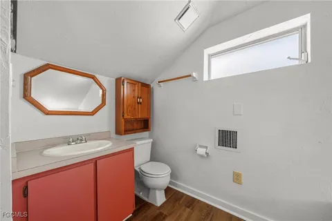 a bathroom with a toilet a sink a mirror and vanity