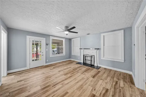 a view of empty room with wooden floor and window