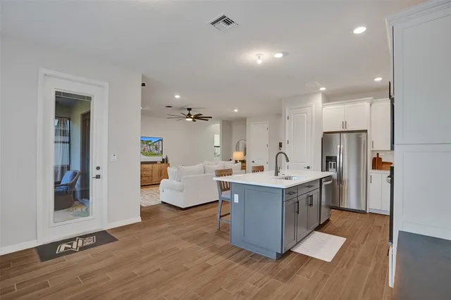 a kitchen with white cabinets and a stove with wooden floor