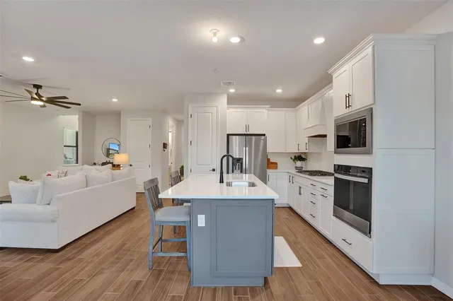 a kitchen with white cabinets and appliances