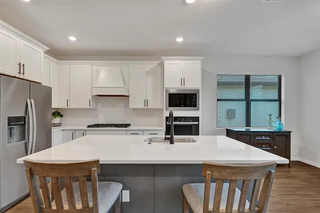 a kitchen that has a microwave a stove a table and chairs in it